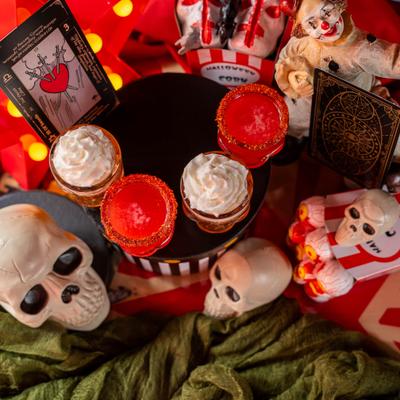 Halloween table setup featuring decorative skulls and a flight of four cocktails.