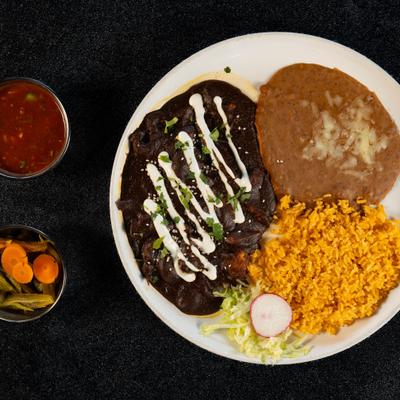 Mole Chicken served with rice, beans, condiments and a drink.