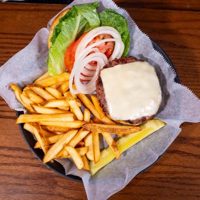 Open-faced cheeseburger with lettuce, tomato, and onions, served with fries.