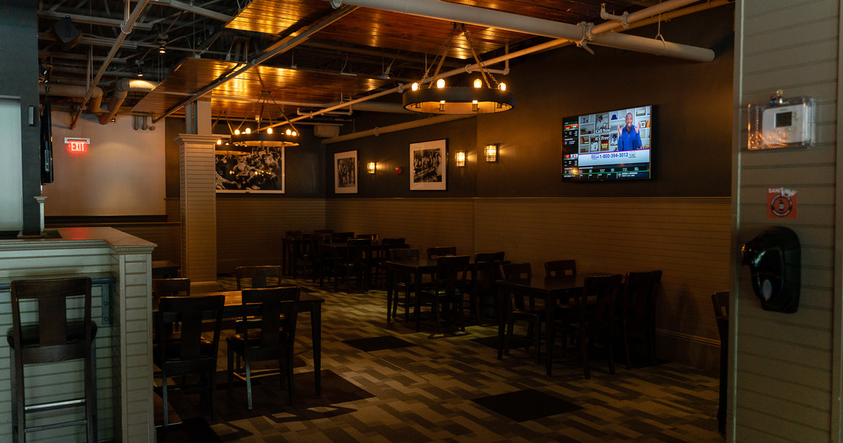 Interior - wooden tables and chairs, flat screen TV attached to the wall, pictures