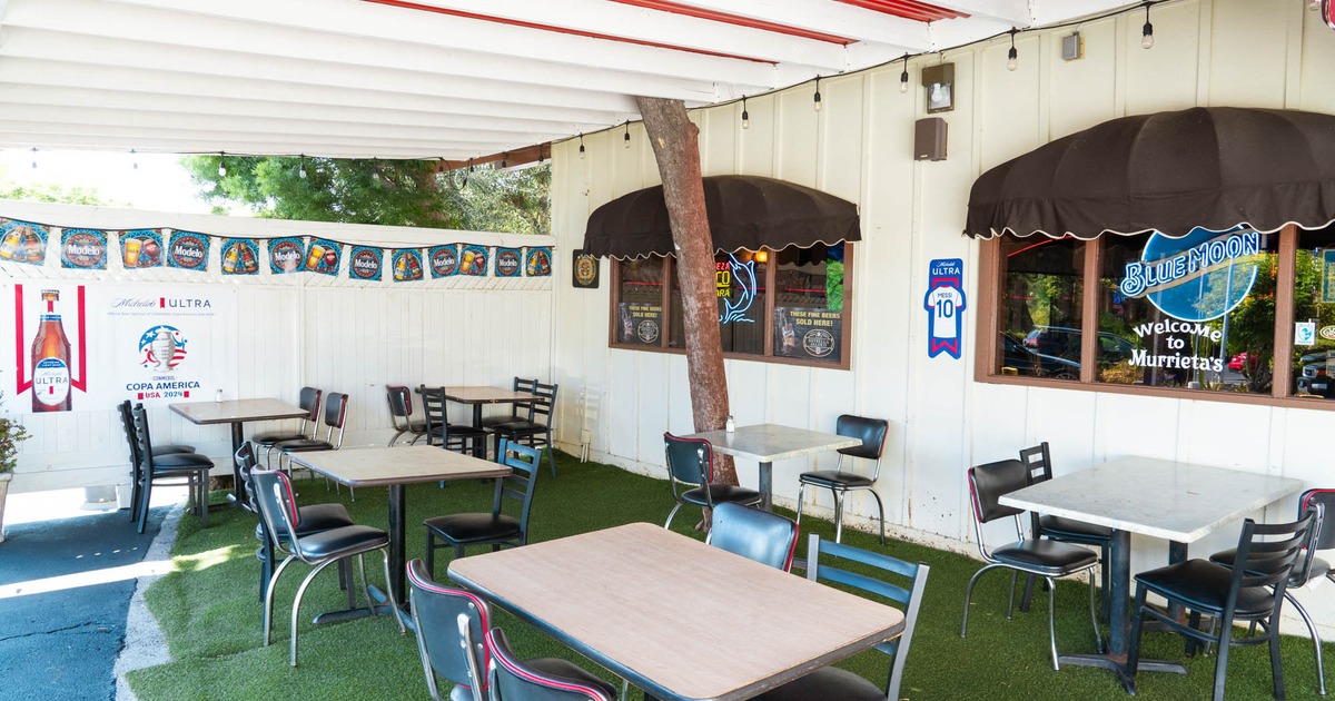 Exterior, patio, tables and chairs, artificial grass flooring, various beer banners