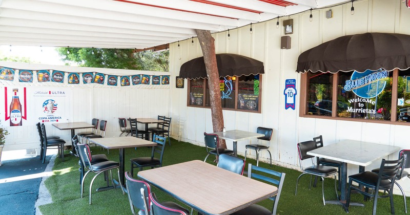 Exterior, patio, tables and chairs, artificial grass flooring, various beer banners