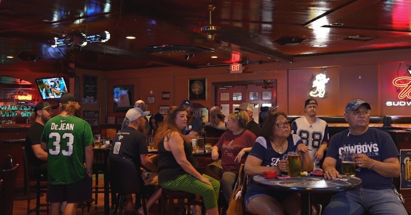 Guests enjoying drinks at tables in bar area