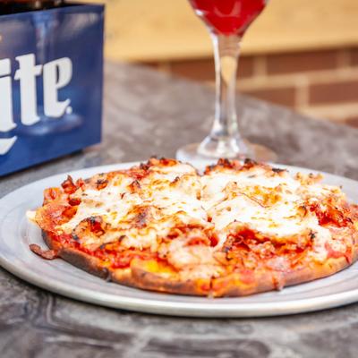 Supreme pizza with pepperoni, sausage, bacon, and cheese.