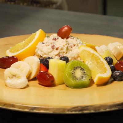 Chicken salad and fresh fruits on a board
