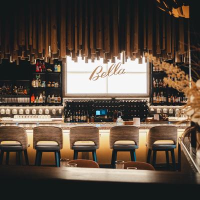 An elegant bar featuring stylish seating and a variety of drinks on display.