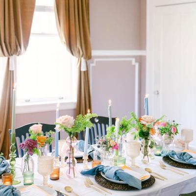Fully set table, with candles and flowers.