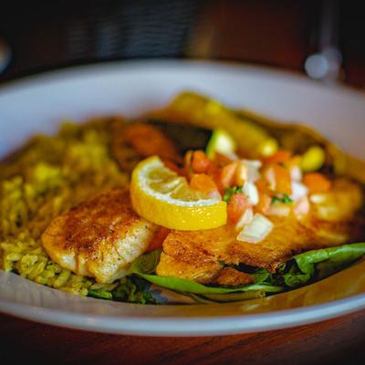 Grilled tilapia served on spinach with cilantro rice and seasonal vegetables.