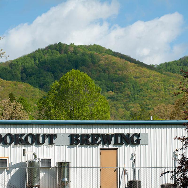 Brewery's building situated against a backdrop of green mountains.