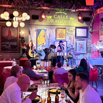 People having dinner while Pedrito camacho is singing on the stage.