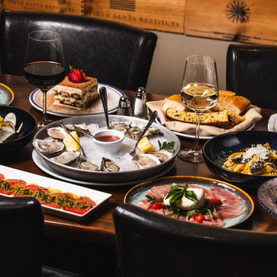 Dining table filled with assorted dishes and wine.