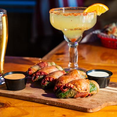 Deep fried jalapenos with cheese feeling, wrapped with bacon, house dips, beer and Margarita.