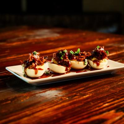 Deviled eggs topped with brisket, scallions, and BBQ sauce.