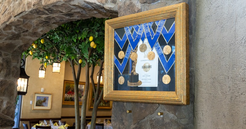 Interior, framed awards on a wall, doorway to a dining room
