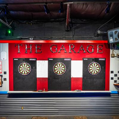 Dartboards mounted against a red and white wall.