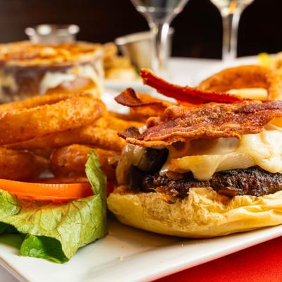 Close-up of a bacon cheeseburger with onion rings
