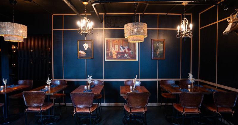 Interior, tables and chairs near wall with pictures