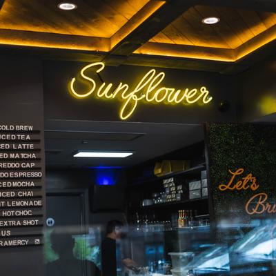 Sunflower cafe interior with a neon sign.