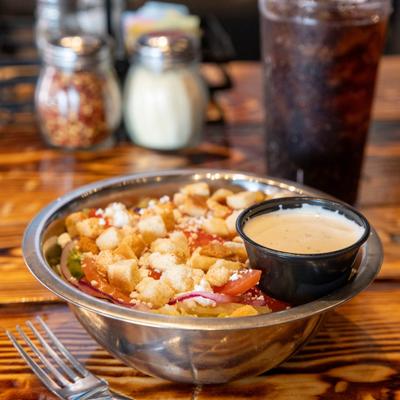 House salad served in a metal bowl with a small cup of ranch dressing.