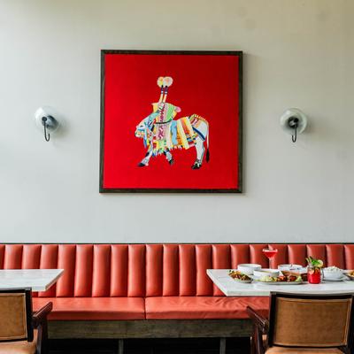 Dining area, banquette seating, framed painting on the wall.