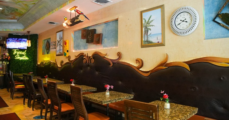 Interior, large decorated banquette bench with tables and chairs, various tropical decorations