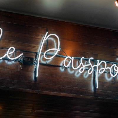 A white neon sign mounted on a dark wooden wall that reads 