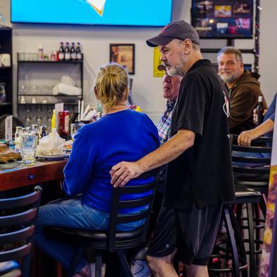 Owner with a couple of guests at the bar counter.