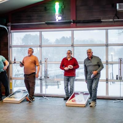 Patrons playing cornhole inside.