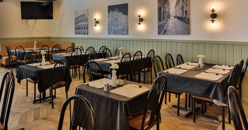 Interior, chairs and several dark wooden tables covered with black tablecloths