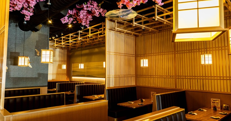Interior - wood lattice screens, glowing lanterns, booth seating, pink cherry blossoms