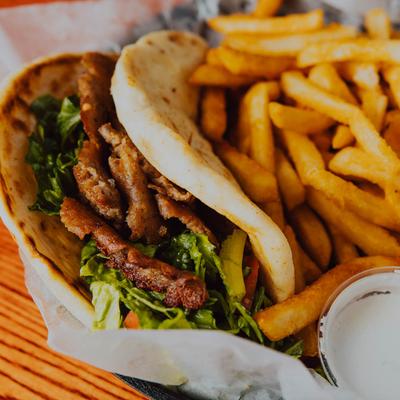 Gyro wrap with fries and dipping sauce.