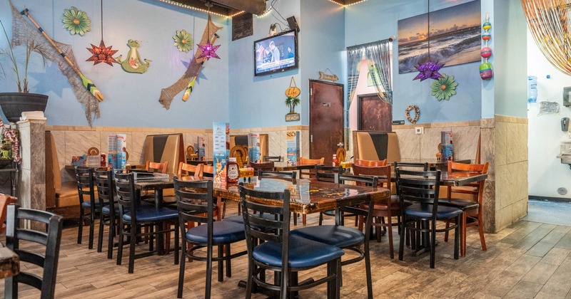 Interior, dining area, wooden top tables for four and six, seating booths in the back