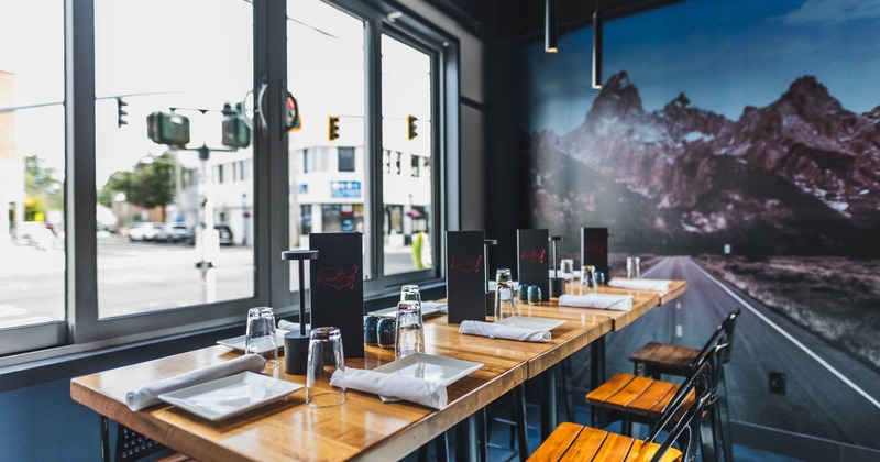 Interior, high top dining tables and chairs by the windows