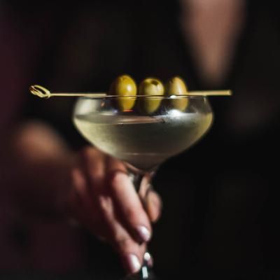 Person serving martini cocktail