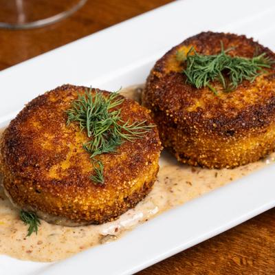 Fresh salmon cakes coated in polenta, pan seared, and served with remoulade.