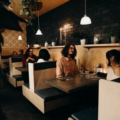 Guests seated at booths under warm lighting.