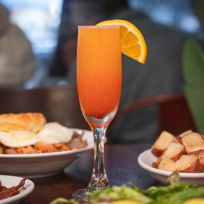 Mimosa surrounded by breakfast dishes.