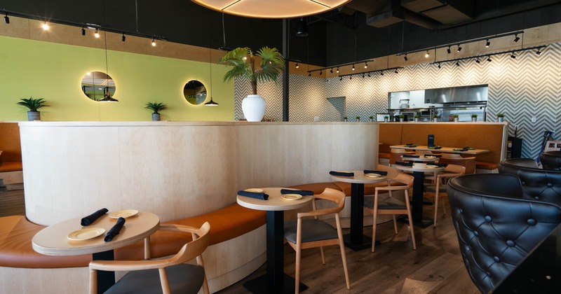 Interior, dining area, stylish curvy banquette bench with round tables and chairs