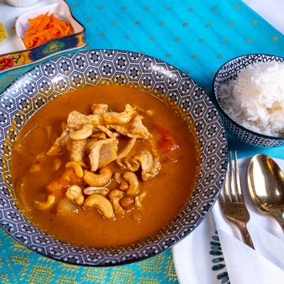 Bowl of Massaman curry served with a side of white rice.