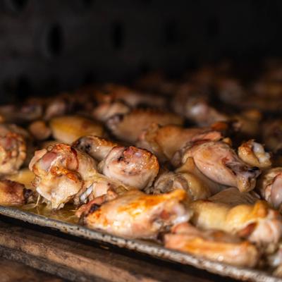 Roasted chicken wings on a tray inside an oven.