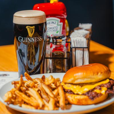 Smash burger with fries and a glass of Guinness.