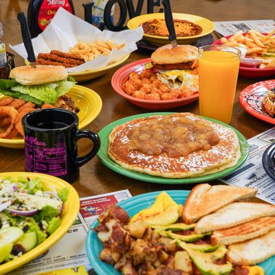 Assortment of breakfast dishes served alongside glass of juice and a cup of coffee.