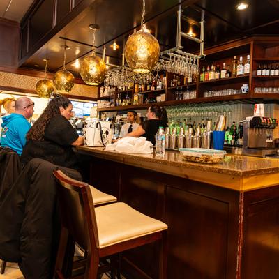 Interior, a bar with seated guests and bar staff.