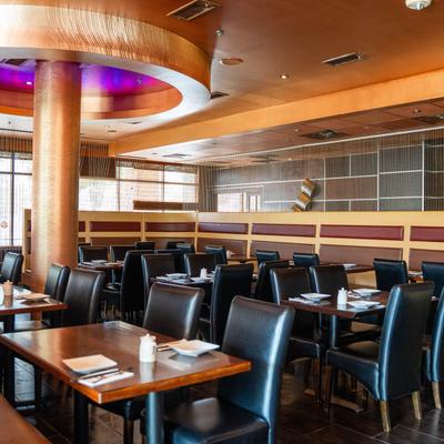 Upholstered chairs and tables in a large dining hall.