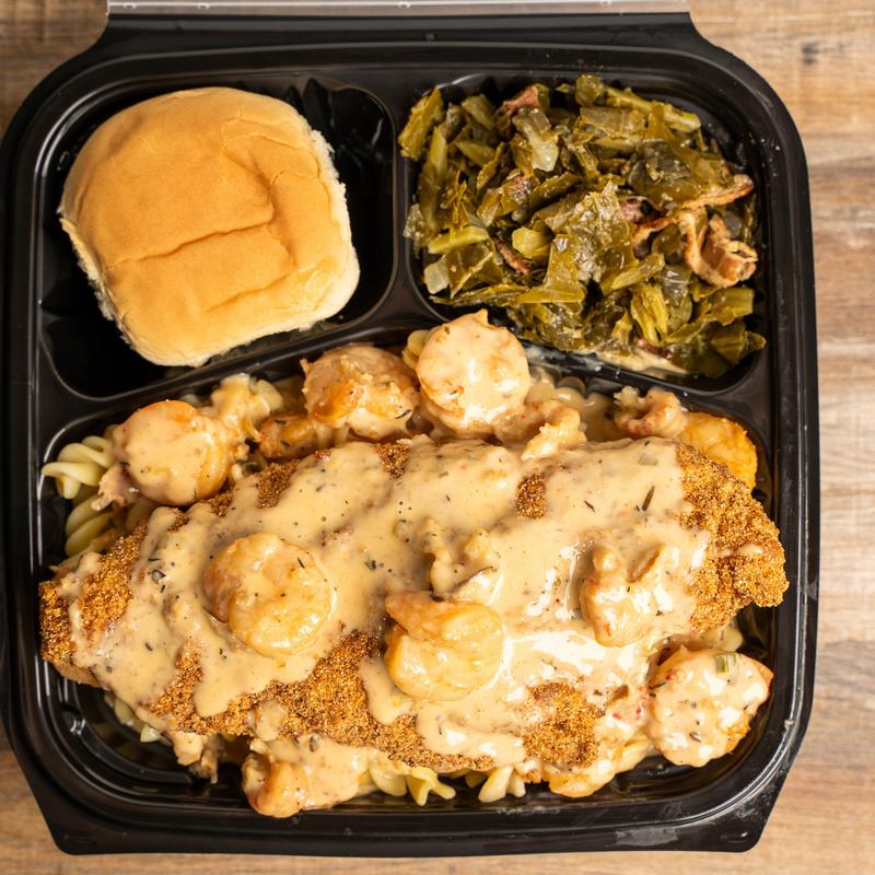 Fried catfish, with shrimp, pasta, sauce, bread roll, and collard greens.