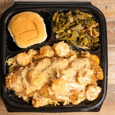 Fried catfish, with shrimp, pasta, sauce, bread roll, and collard greens.