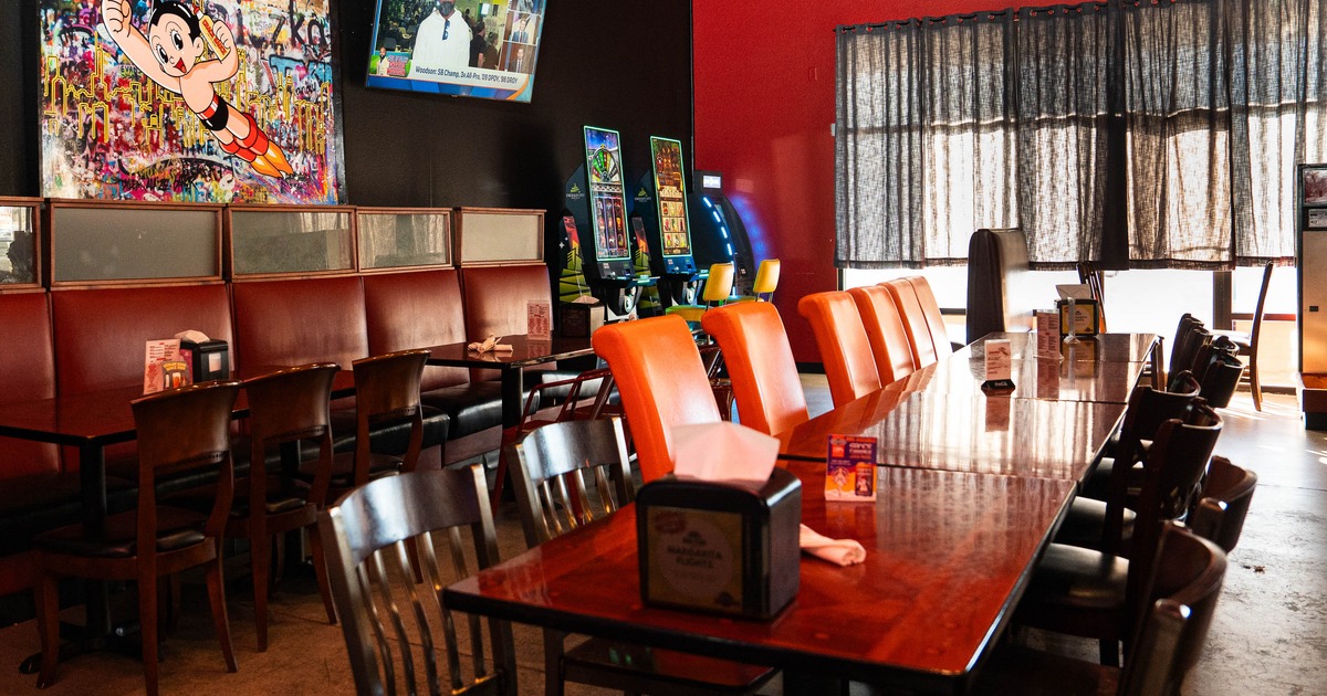 Cozy restaurant interior with wooden tables, colorful chairs, and comic themed art