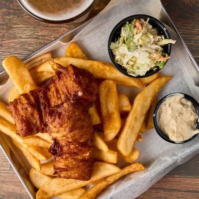 Fish and chips with coleslaw and dipping sauce.