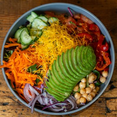 Garden salad with avocado, chickpeas, cucamber, cheese and shredded carrots.