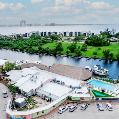 Aerial view of a waterfront bar and marina with an outdoor pool.